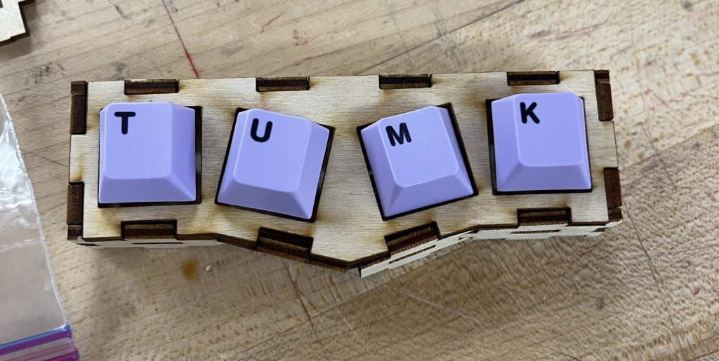 Three-dimensional slanted rectangular box with holes cut-out. Design reflects the SolidWorks design, keycaps added onto the mechanical switches.