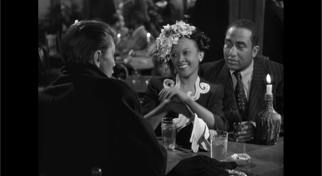 A screenshot of a film noir black and white movie. Pictured are two African American patrons of the bar, and a white private detective whose face cannot be seen.