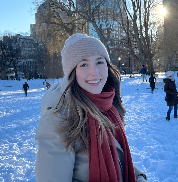 Photo of Sofia Levy in a beige beanie, beige winter coat, and red beanie standing in the snow in Boston Commons.