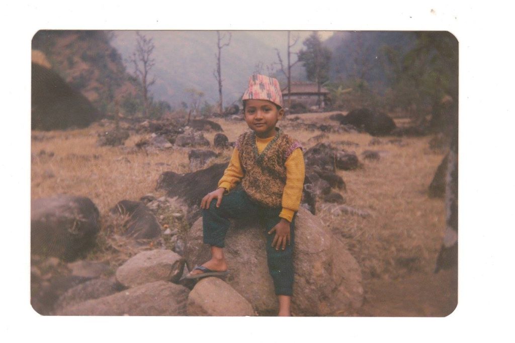 Milan Dahal as a small child with a traditional Nepali hat