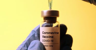 Image of hand with glove holding COVID-19 vaccine