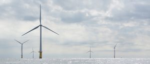 Landscape photo of offshore windmills against a background of clouds