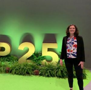 Photo of Bethany Tietjen at COP 25 in front of logo statue