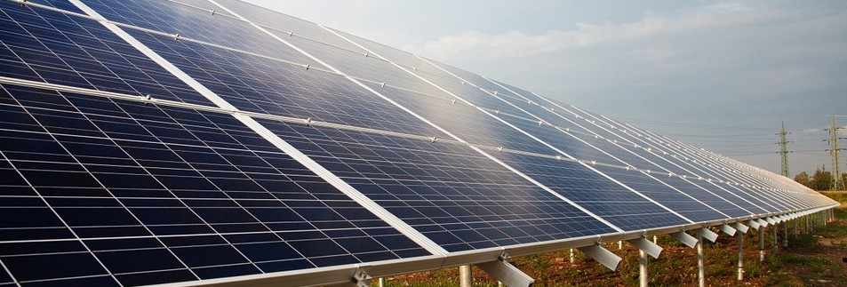 Solar array in field with power lines in distance