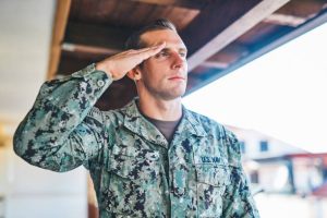 Shot of a young soldier standing and saluting outdoors