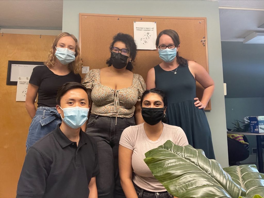 Photograph of five members of the DICE Lab standing in the lab space.