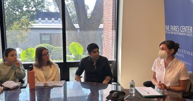 Professor Eldridge speaks to the room in front of a Fares Center banner. Three students are pictured listening.