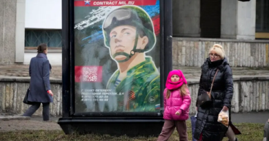 People walk past an army recruiting billboard