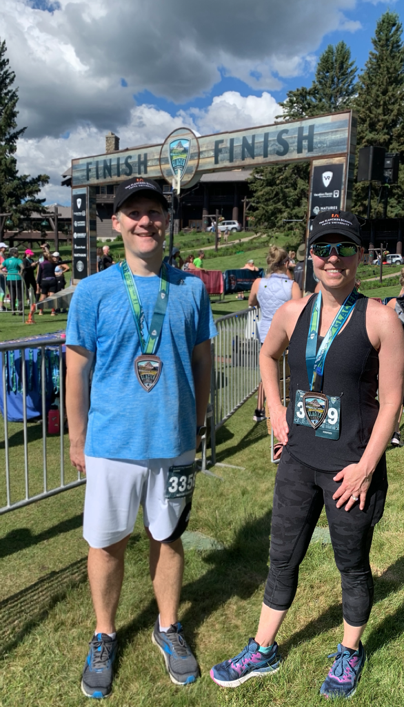 GBA students Mat G. and Amy W. pose for a picture in front of the finish line at the Glacier Half Marathon. 