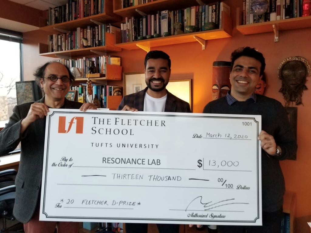 Three men are shown with a large check for 13,000 dollars in seed capital.