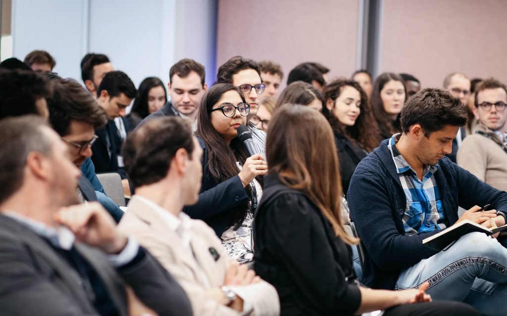 Woman speaks in a crowd of people.