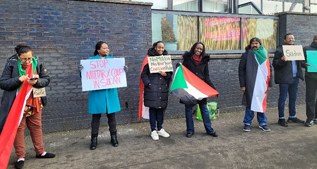 Six protesters stand on the street in Scotland.