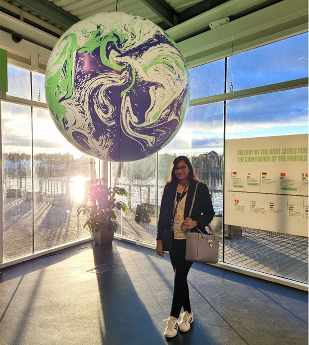 Ramsha Hameed standing in front of giant globe at the conference.