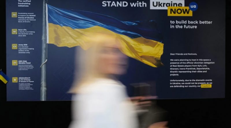 Screen grab from Foreign Press story. Woman in front of a blue and yellow Ukrainian flag