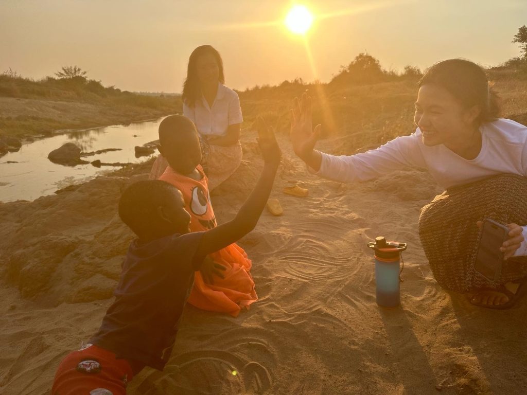 Melanie high-fiving kid in Malawi