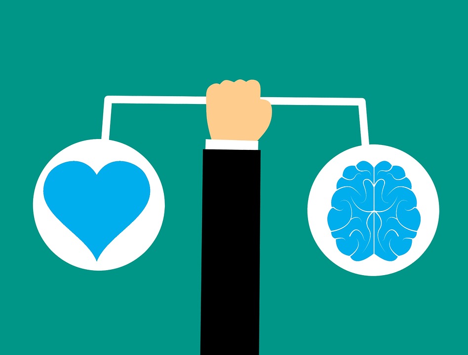 Cartoon image of a hand holding a bar, where left side of the bar hangs a heart, and the right side of the bar hangs a brain