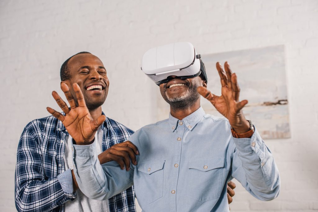 a son showing his father how to use a VR headset