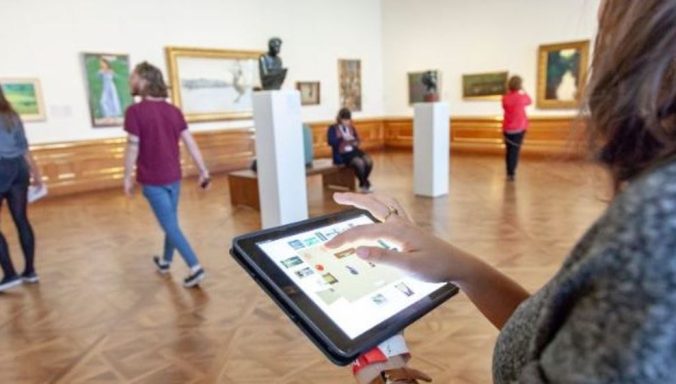 Evaluator in an art museum uses a tablet to track visitor behavior