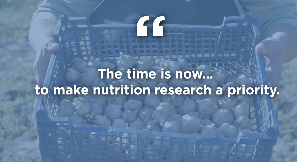 A blue-tinted photo of a basket of harvested brussels sprouts is overlaid with a quote that says the time is now to make nutrition research a priority.