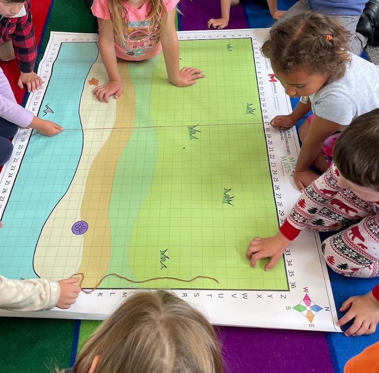 young children playing on a map of a beach on the floor