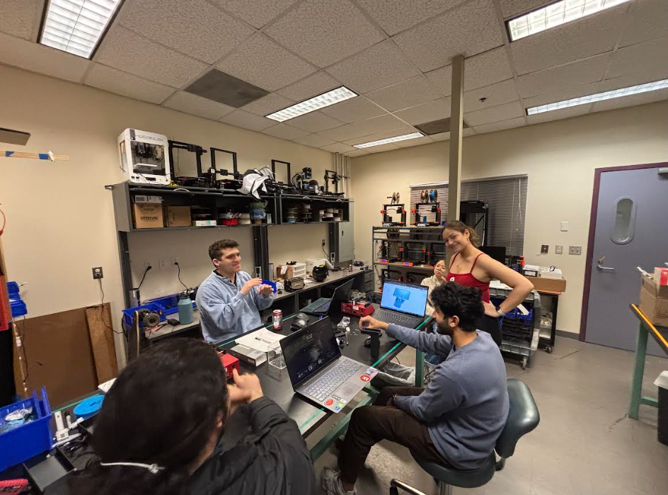 Riley, Omar, Zahir, Maya, and Amanda sitting around a table in the Science and Technology Center, room 106.