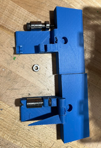 Our device disassembled into two halves. The bottom half remains in tact, but the shoulder bolt and bearings have completely broken off the device.