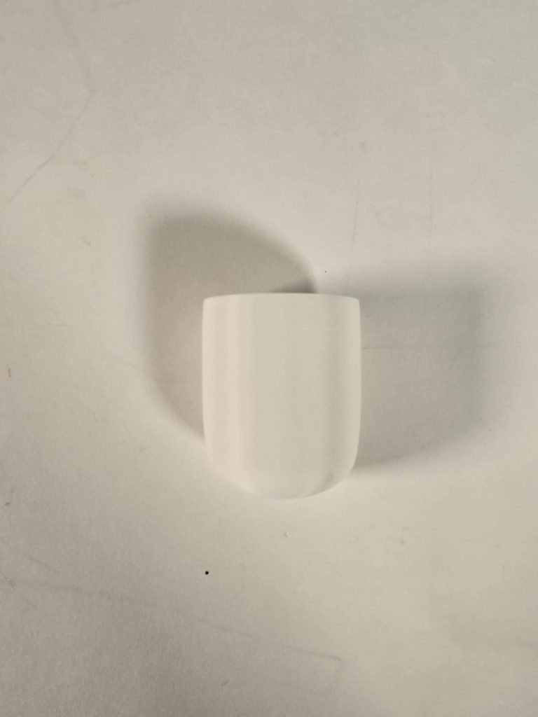 Image shows a 3d printed white elliptical cylinder squeezing component.