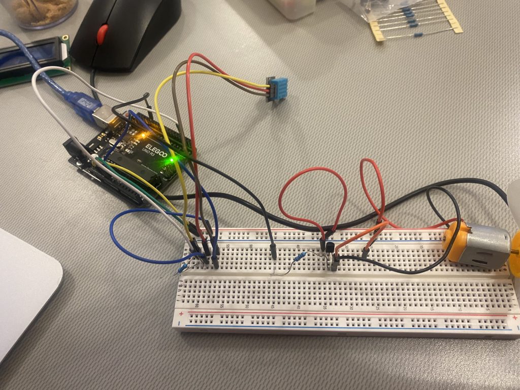 Picture includes a breadboard involving wires and connected to the UNO R3 Controller Board with wires. DHT11 sensor and Fan Motor are also connected to breadboard.