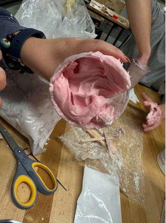 Picture including a cup having the hand shape in the mixed pink molding material.