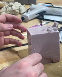 Picture including a cube of mold with a funnel at the top.