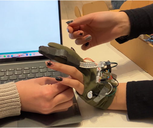 A picture of the glove being worn while testing the functionality of the pressure sensor.