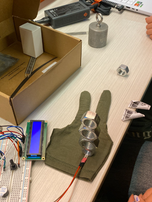 Picture of using weights to determine the weights equivalent to the sensor reading value from team members' averaged hand clenching.
