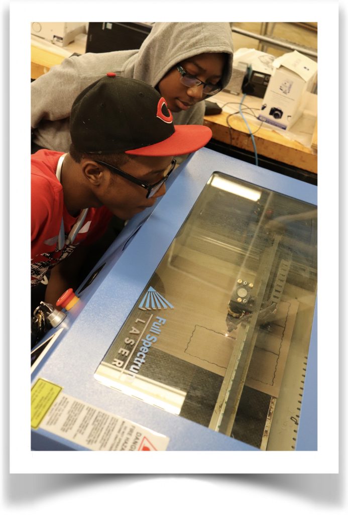 A student looking at a laser cutter.