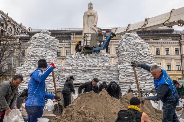 Residents in Kyiv protect a statue to St. Olha with sandbags